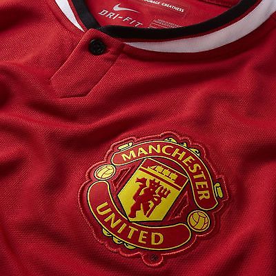 Primer plano del cuello polo blanco con botón oculto y escudo del Manchester United en jersey Nike 2014 original