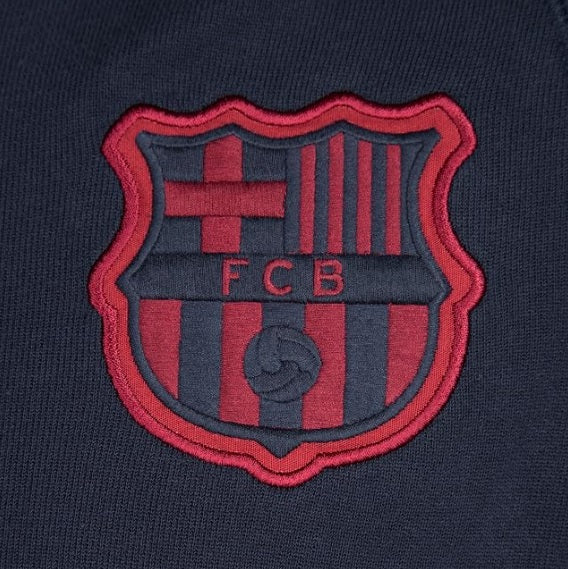 Primer plano del escudo bordado del FC Barcelona sobre el tejido azul marino de la sudadera Nike AW77 Covert 2014/15 en Futbol90MX
