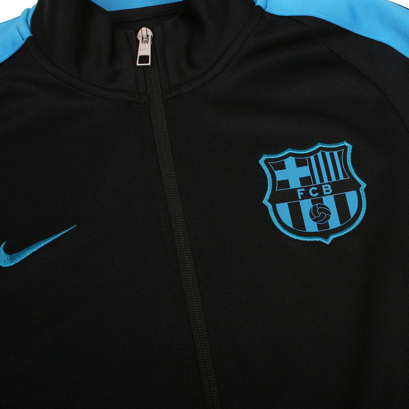Detalle del escudo bordado del FC Barcelona y logotipo Nike en chamarra N98 negra.