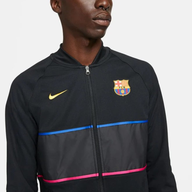 Acercamiento al pecho de la chamarra Nike I96 del Barça mostrando el escudo bordado de alta definición y el Swoosh amarillo en Futbol90MX