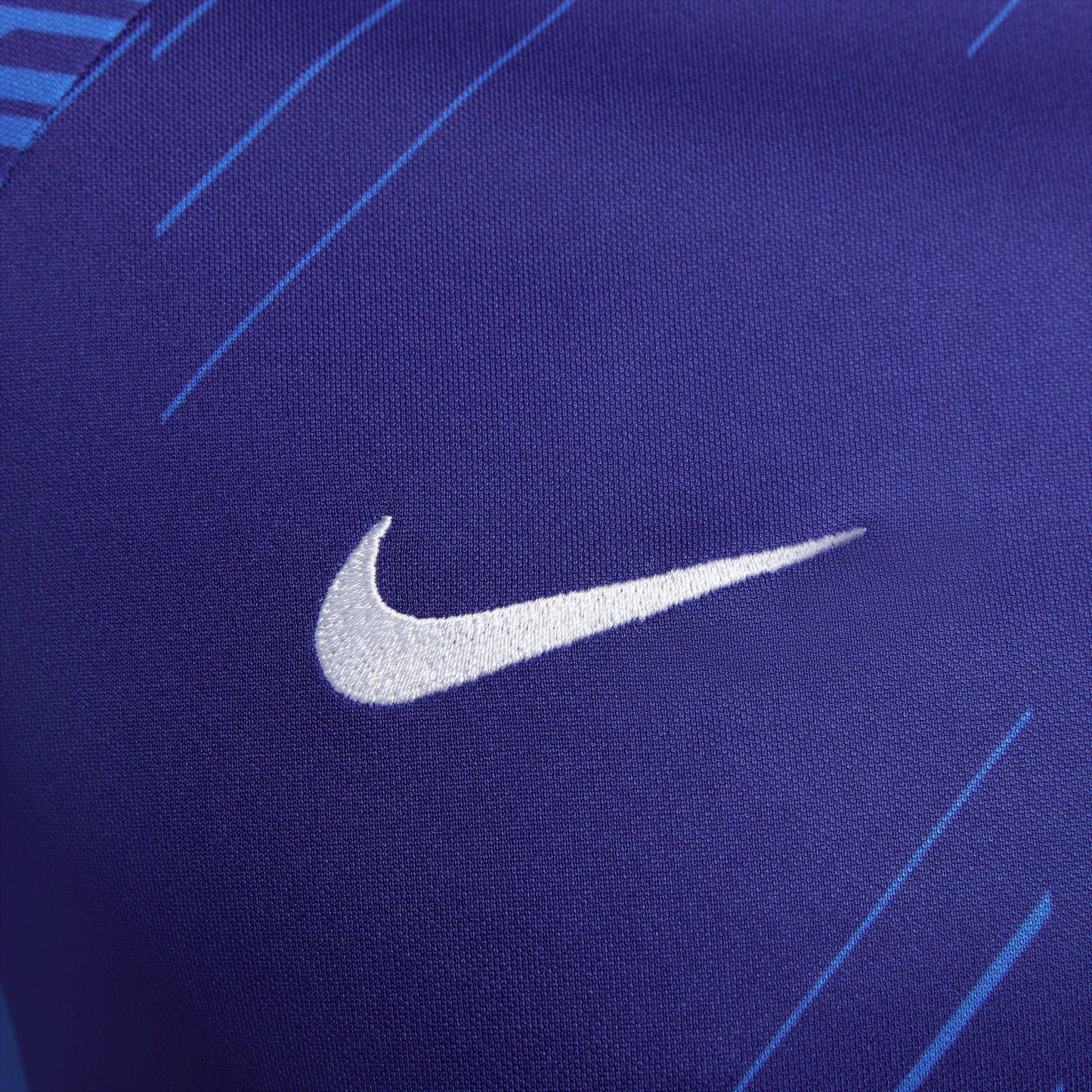 Primer plano del logotipo Nike Swoosh sobre tejido técnico de alto rendimiento.