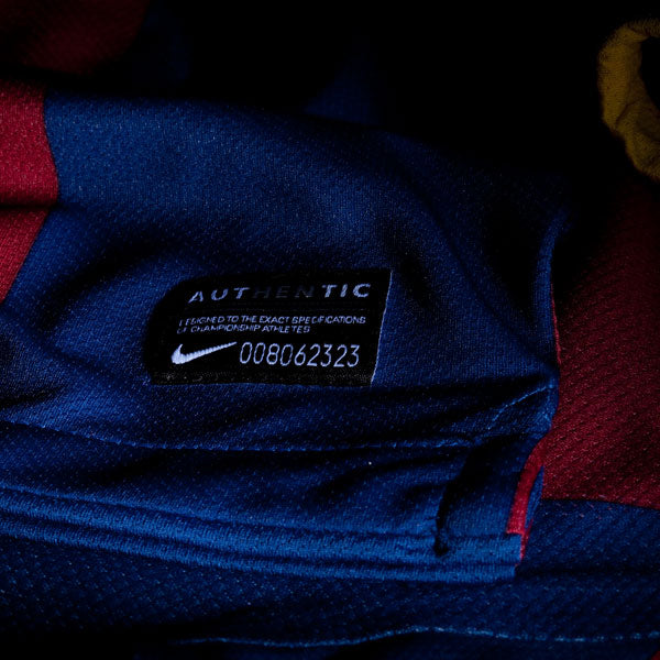 Primer plano de la etiqueta negra inferior de autenticidad de la versión de jugador Authentic Match del jersey Nike Messi FC Barcelona local 2010/11 (Ref. 406809-486) en Futbol90MX.