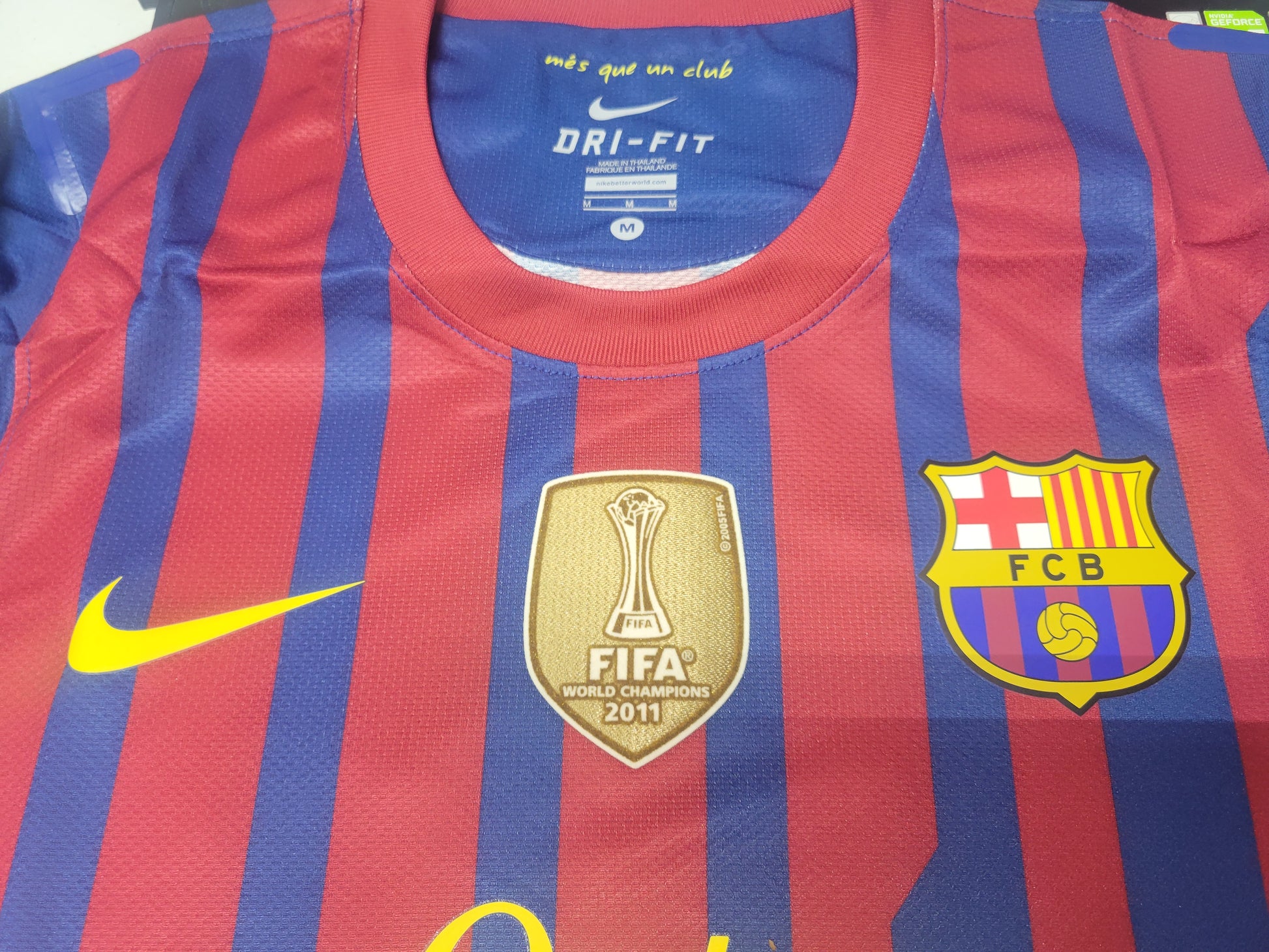 Nike logo, escudo del FC Barcelona y parche de Campeón del Mundo FIFA 2011 termosellados en versión de utilería.
