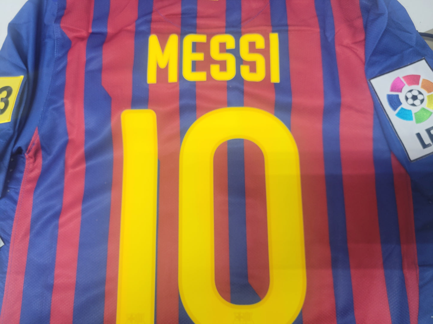 Acercamiento al nombre y numero oficiales Messi 10 en jersey authentic match local 2011/12 de FC Barcelona.