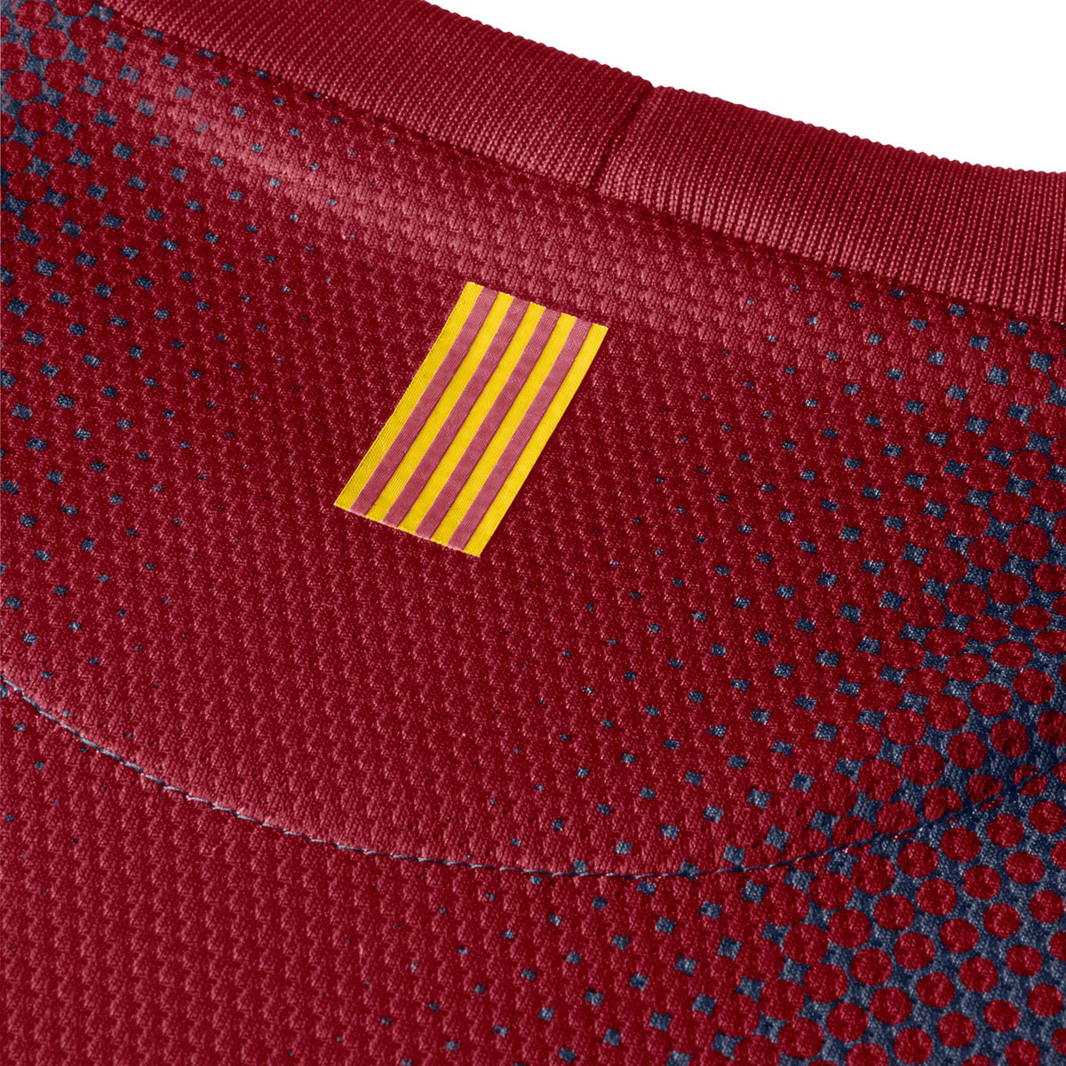 Detalle en primer plano de la parte posterior del cuello que muestra la bandera de la Senyera catalana sobre el tejido azul marino y rojo del modelo 478323-410 en Futbol90MX.