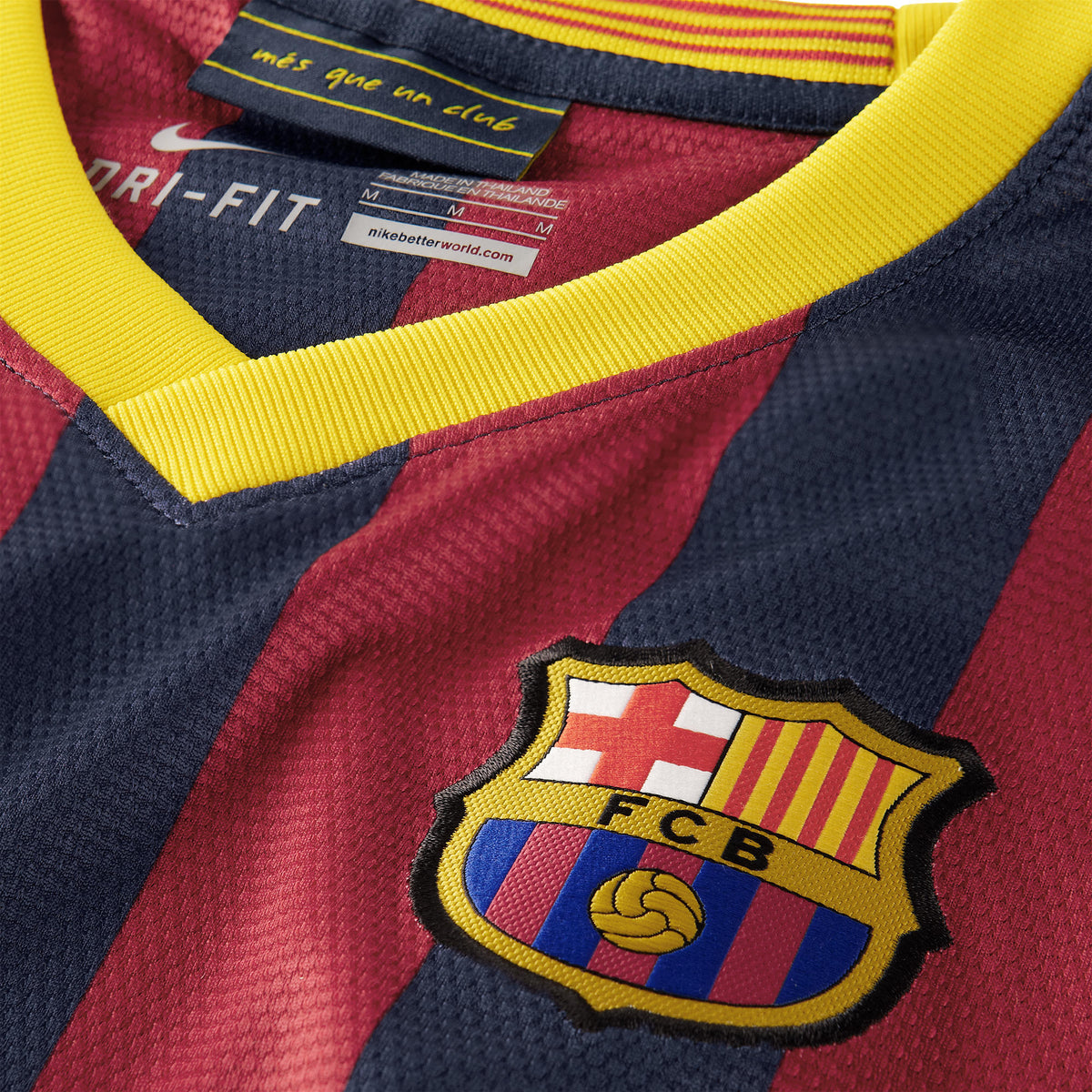 Detalle en primer plano del cuello en V amarillo y el escudo bordado del FC Barcelona en el jersey de Messi de la temporada 2013/14 (Ref. 532822-413) dentro de Futbol90MX