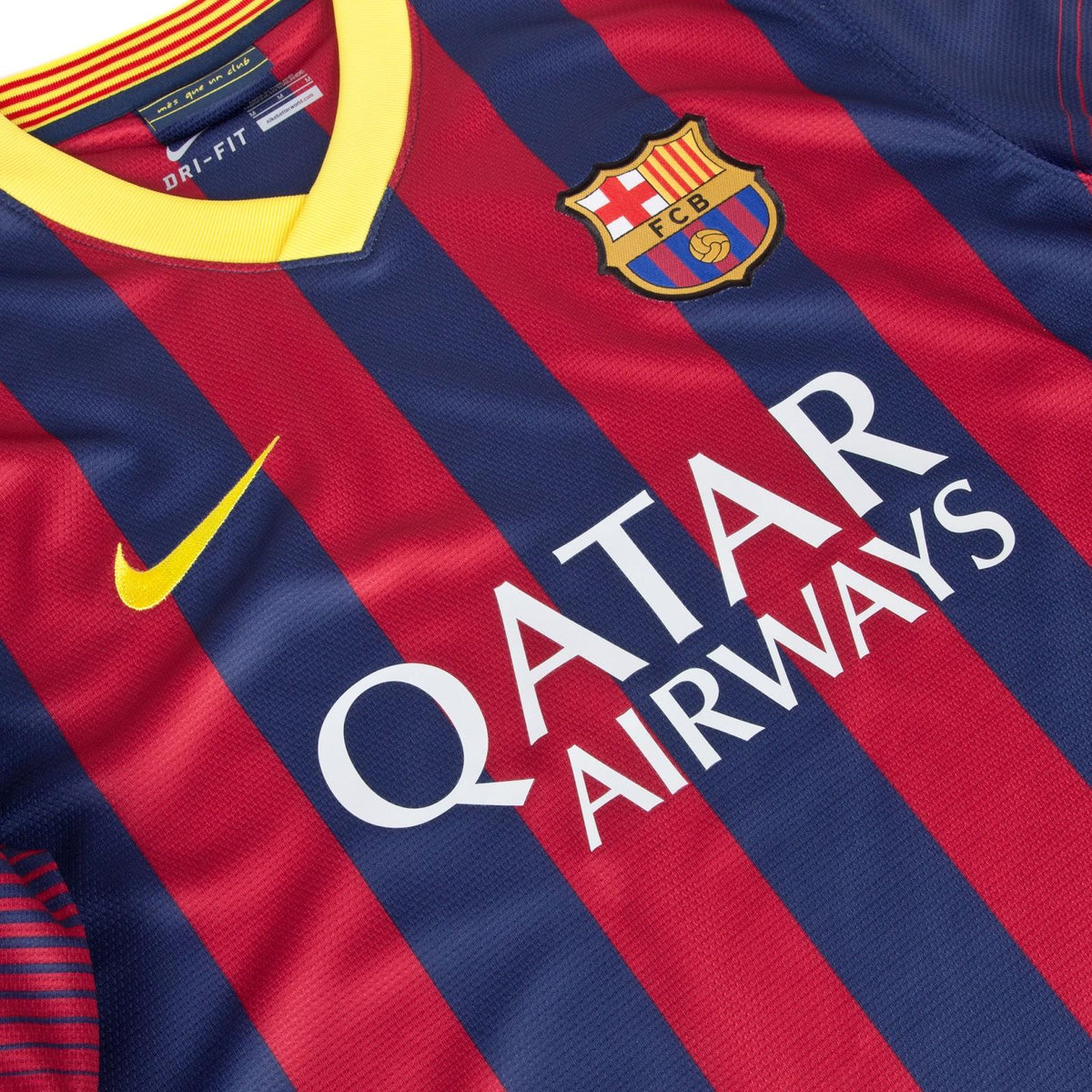 Vista de plano frontal del jersey Nike FC Barcelona 2013/14 en Futbol90MX, destacando el icónico cuello en V amarillo, el lema "més que un club", el escudo del club, logo de NIke  y el patrocinio frontal "Qatar Airways" (Ref. 532822-413)