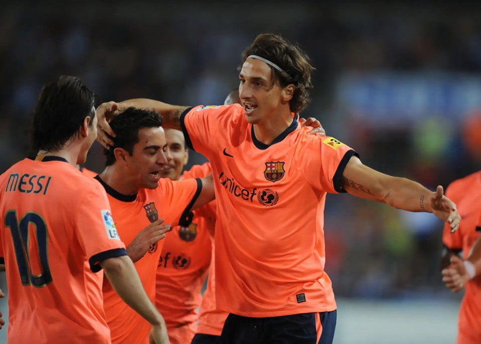 Zlatan Ibrahimović celebrando un gol con Xavi Hernández y Lionel Messi luciendo la serigrafía MESSI 10 en el jersey visitante del FC Barcelona 2009/10 (Ref. 355020-870) en Futbol90MX