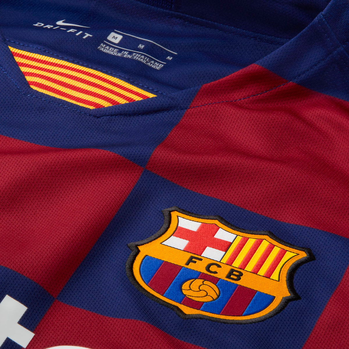 Primer plano del patrón de cuadros ajedrezados en azulgrana y el escudo oficial del FC Barcelona en el jersey de manga larga de Lionel Messi 2019/20 (Ref. AJ5673-457), en Futbol90MX