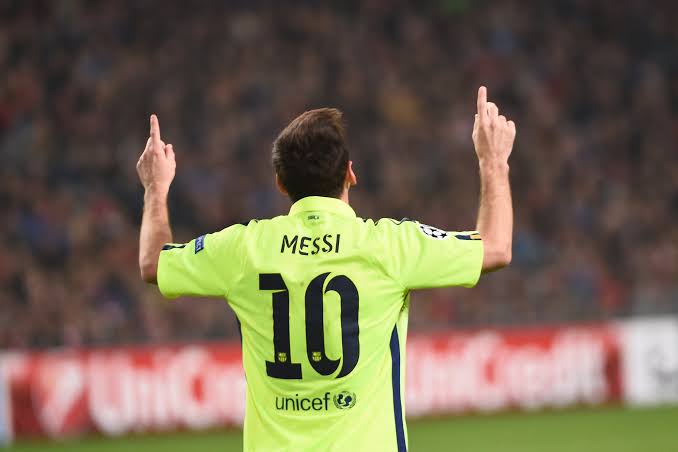 Vista posterior de Lionel Messi celebrando con los brazos en alto y el dorsal #10, portando el jersey Nike FC Barcelona tercero UCL 2014/15 (Ref. 631192-711) en color Volt en Futbol90MX