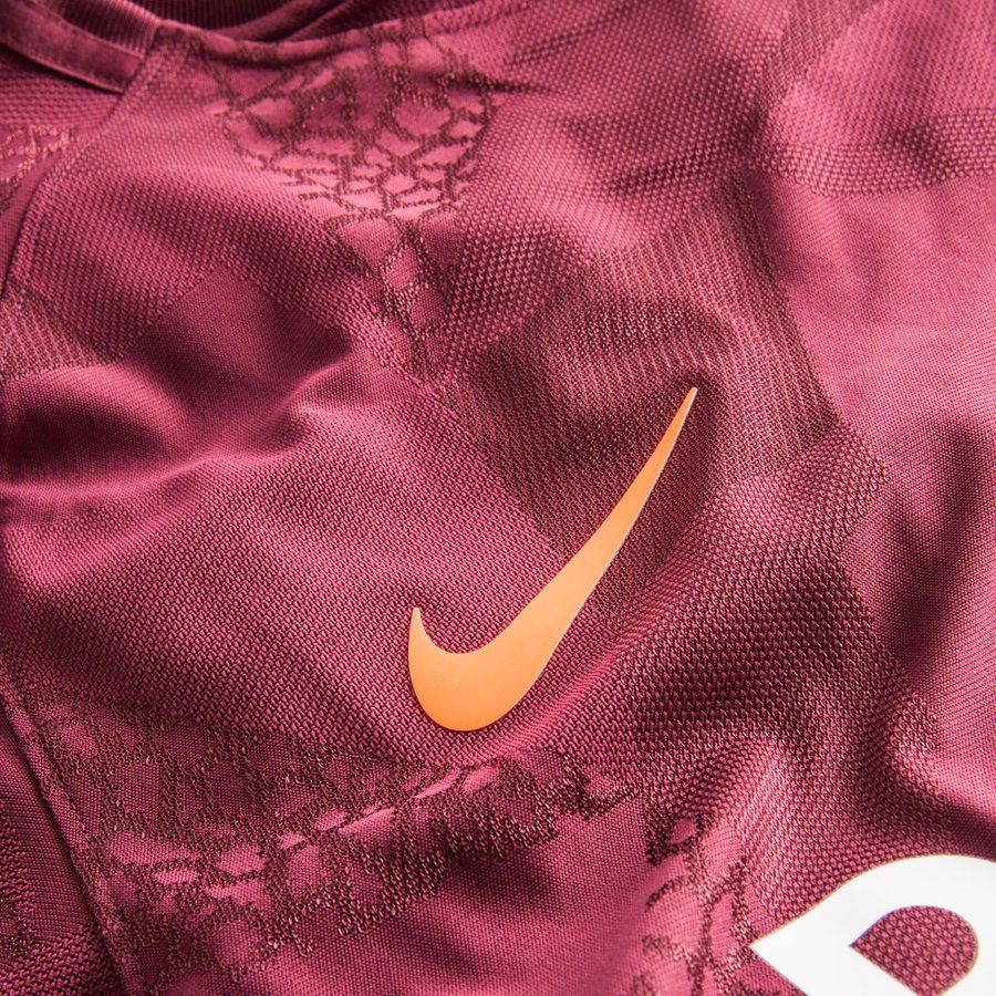 Primer plano del logotipo Nike Swoosh termosellado en color naranja brillante sobre el patrón geométrico abstracto de la tercera equipación vapor match de Messi UCL del FC Barcelona 2017/18 (Código: 847188-683) en Futbol90MX.