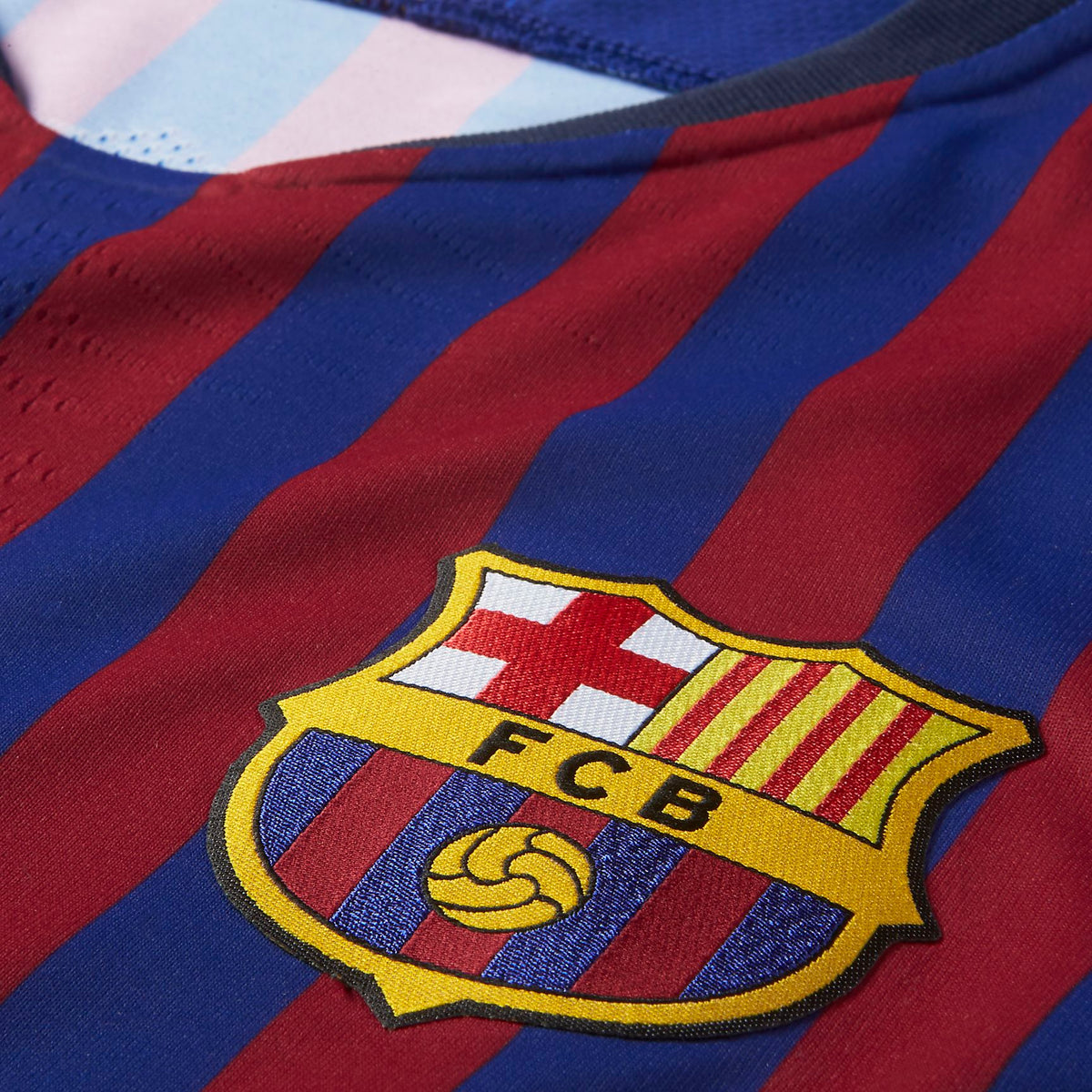 Primer plano del escudo del FC Barcelona termosellado en alta densidad y el tejido texturizado Nike VaporKnit del jersey vapor match de local del FC Barcelona 2018/19 de Luis Suarez.