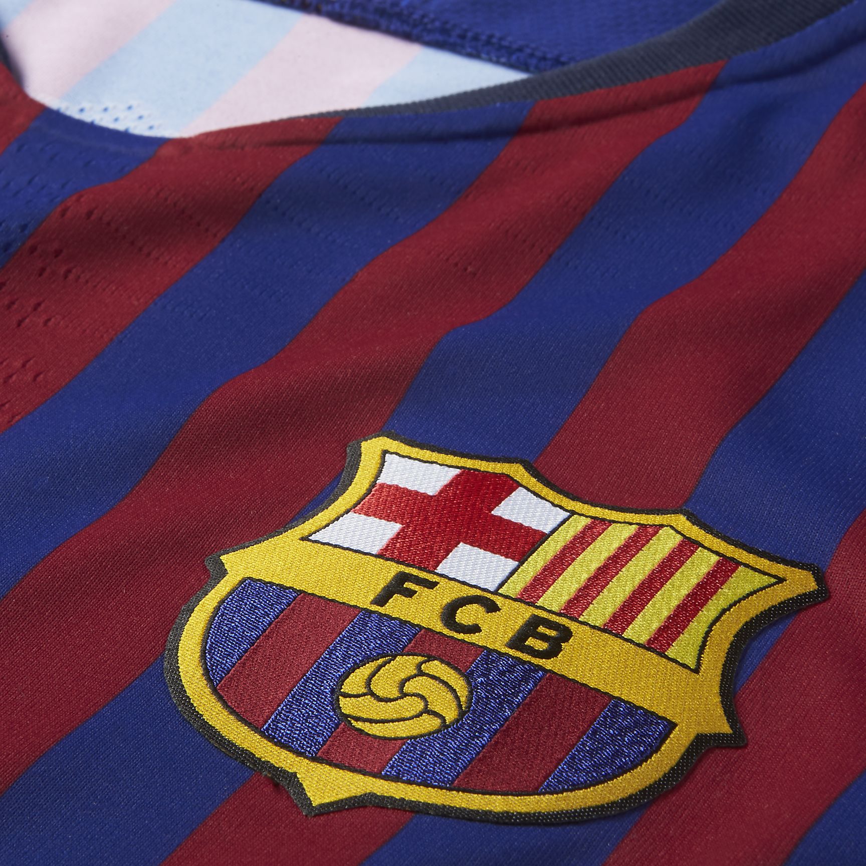 Primer plano del escudo del FC Barcelona termosellado en alta densidad y el tejido texturizado Nike VaporKnit del jersey vapor match de local del FC Barcelona 2018/19 de Luis Suarez.