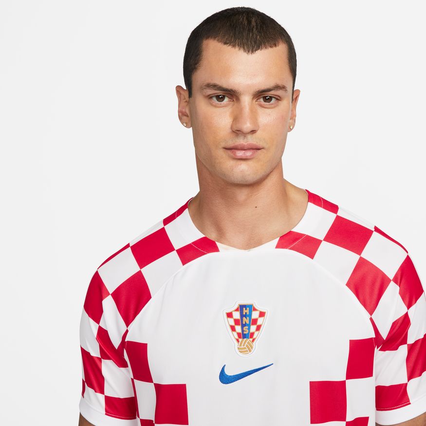 Primer plano del escudo de Croacia y del logotipo Nike Swoosh en color azul, aplicado con precisión sobre el tejido técnico del jersey de local de Luka Modrić Mundial 2022, stock Futbol90MX