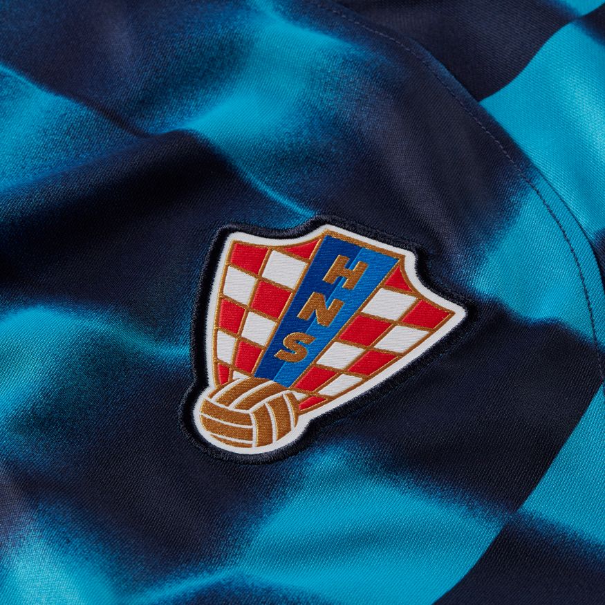 Primer plano del escudo de la Federación Croata (HNS) bordado en el pecho del jersey de visita Mundial 2022. Detalle de precisión artesanal en el tejido técnico, stock Futbol90MX