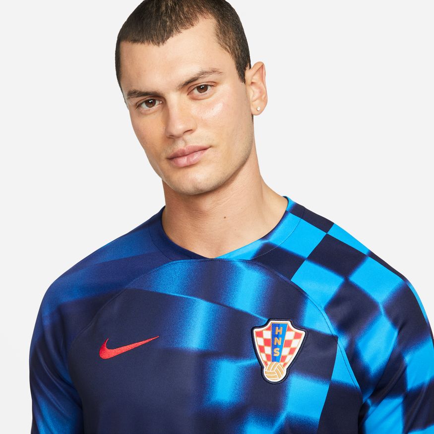 Primer plano del Escudo de Croacia y el logotipo Nike Swoosh en color rojo, aplicado sobre el tejido técnico Dri-FIT del jersey oficial de Luka Modrić, edición mundialista 2022.