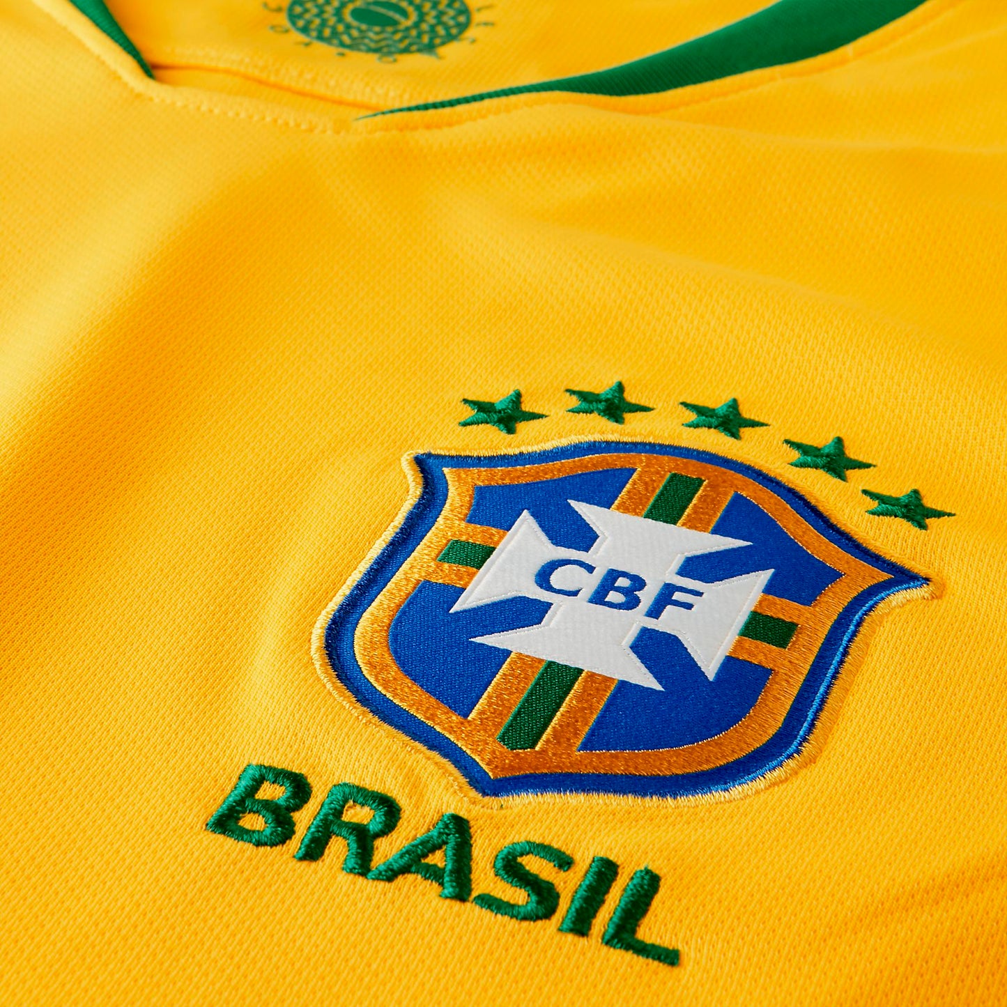 Vista frontal del jersey amarillo "Midwest Gold" de la Selección de Brasil 2018 close up en el escudo