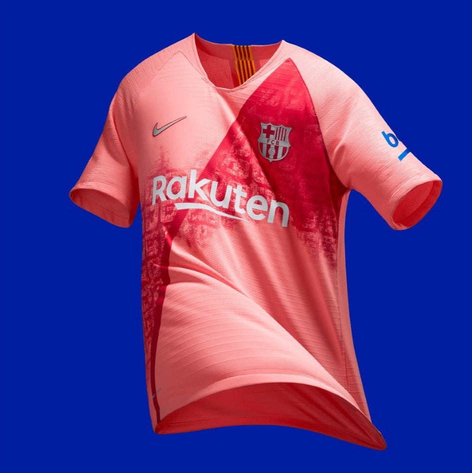 Vista flotante de estudio del Nike FC Barcelona Third Jersey 2018/19 Coutinho (Ref. 918989-694) en coral salmón con trama de la Diagonal sobre fondo azul en Futbol90MX