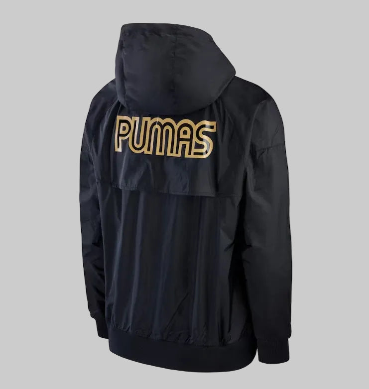 Vista tres cuartos en ángulo posterior de la chamarra negra de Pumas 2023, detallando la caída de la capucha y el ajuste de la espalda alta Nike DX7963-014