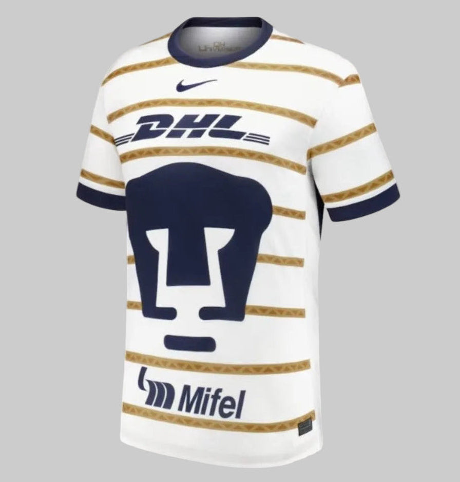 Jersey de local Nike FN8783-101 Pumas UNAM 2024/25 en color blanco con el icónico escudo del Puma en azul obsidiana y franjas horizontales doradas inspiradas en el diseño de 1997, disponible en Futbol90MX