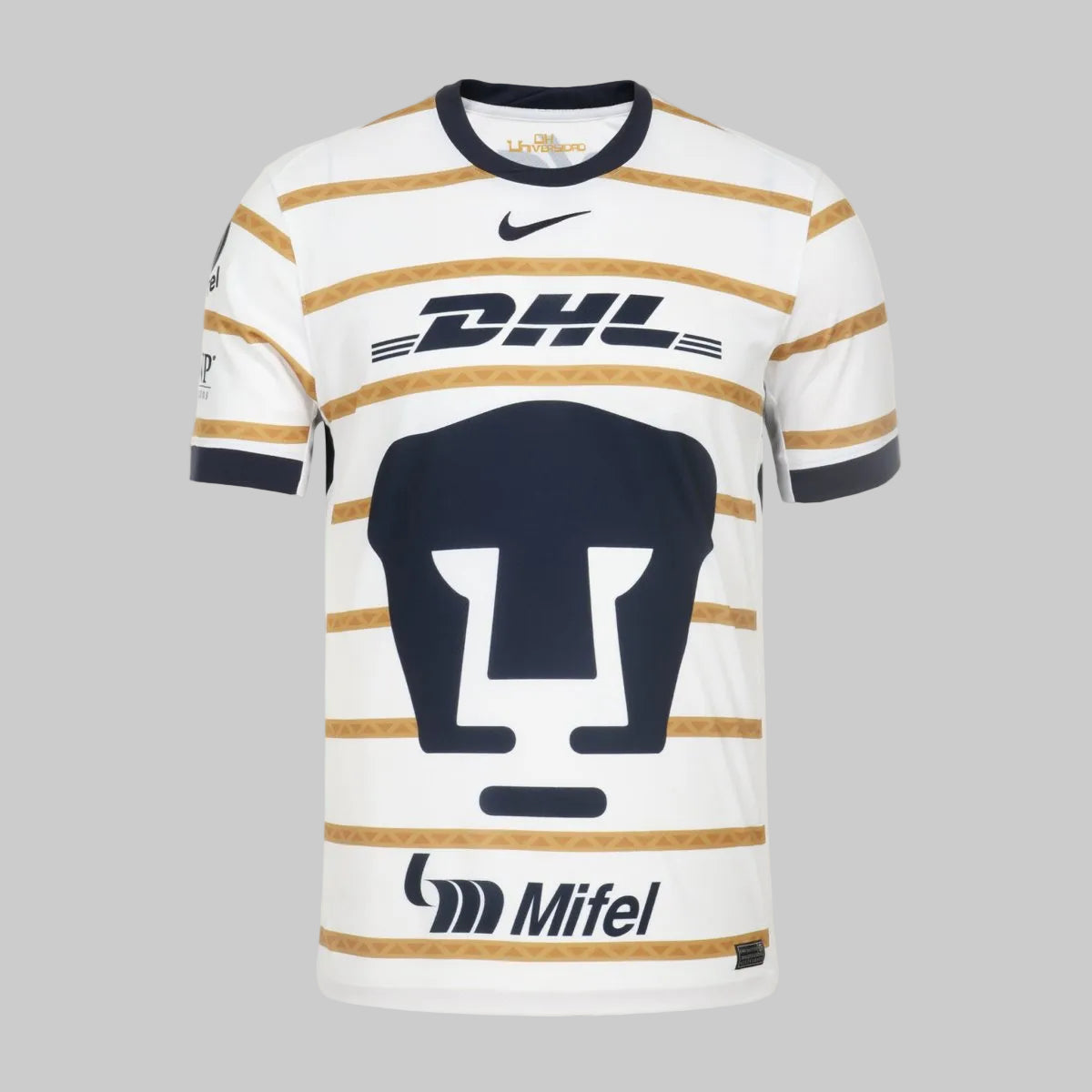 Primer plano del escudo del Club Universidad Nacional en azul marino sobre el panel frontal del jersey Nike, resaltando la jerarquía visual del diseño de casa.
