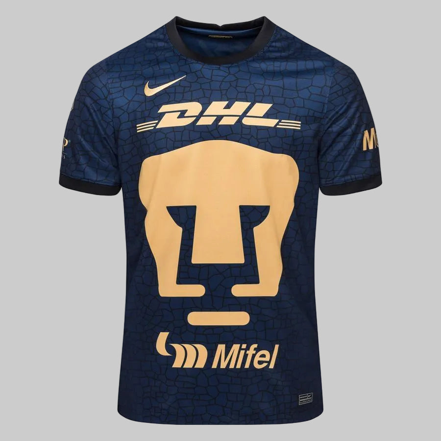 Primer plano del escudo del Puma en color oro sobre tela con textura orgánica del Pedregal Nike 2021