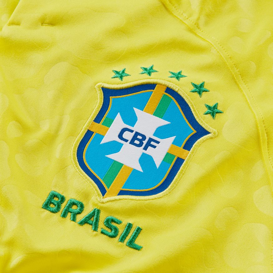 Close-up del escudo de la CBF con cinco estrellas sobre el tejido jacquard de jaguar del jersey de Brasil Mundial 2022 de Vini Jr