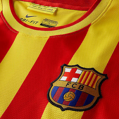 Detalle de la zona frontal del pecho del jersey Nike Xavi FC Barcelona Away 2013/14 (Ref. 532823-703) mostrando el escudo bordado del club, el cuello con la etiqueta interior "Més que un club" y la tecnología Nike Dri-FIT en Futbol90MX.