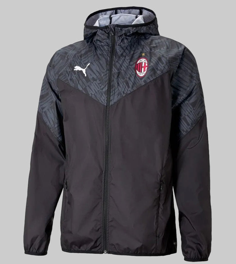 Vista frontal de la chamarra de calentamiento Puma del AC Milan 2020/21 (Ref. 758633 02) en Futbol90MX, destacando su diseño en color negro, capucha integrada con patrón tonal y el escudo oficial del club