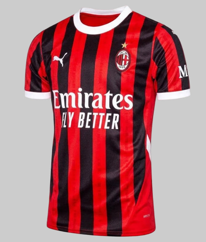 Vista frontal ligeramente angulada del jersey Puma AC Milan de casa 2024/25 (Ref. 774979 01) con bastas rossoneras y cuello blanco, disponible en la Historical Archive Boutique de Futbol90MX