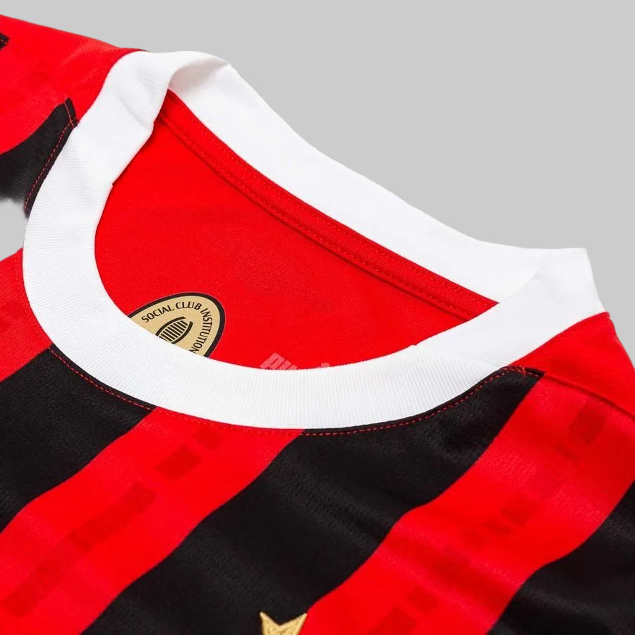 Acercamiento al cuello blanco acanalado del jersey Puma AC Milan titular 2024/25 (Ref. 774979 01) resaltando el sello interno "Social Club Institution" y las franjas rossoneras en Futbol90MX