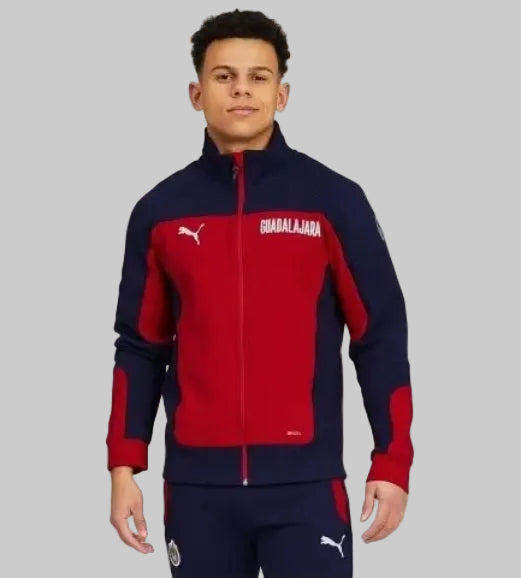 Vista frontal en modelo de la chamarra con cierre completo Puma Evostripe Chivas 2021, código 758759 01, mostrando el gráfico "GUADALAJARA" y la silueta institucional completa en Futbol90MX