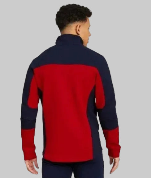 Vista posterior en modelo de la chamarra Puma Evostripe Chivas 2021, código 758759 01, mostrando el ajuste ergonómico y el diseño bitono de la espalda en Futbol90MX