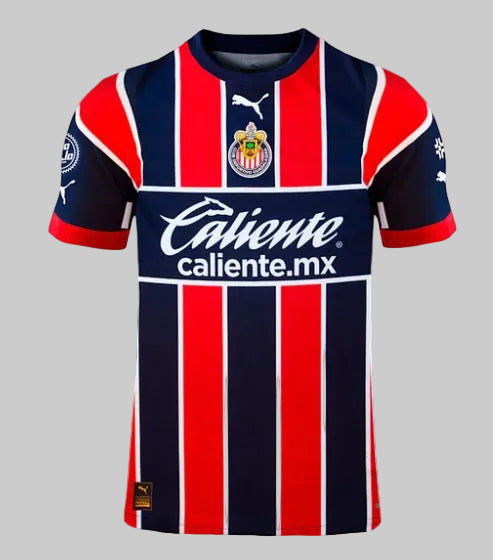 Primer plano del patrocinador principal Caliente.mx sobre la tercera equipación azul marino de la camiseta Puma Chivas Authentic Match 2023 (Ref. 705578 01) en Futbol90MX.