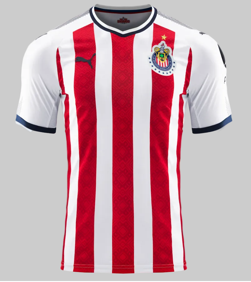 Vista de detalle del cuello en V y los hombros del jersey local de Chivas 2017/18, resaltando los acabados en azul marino y la tecnología de tejido de la marca, en Futbol90MX