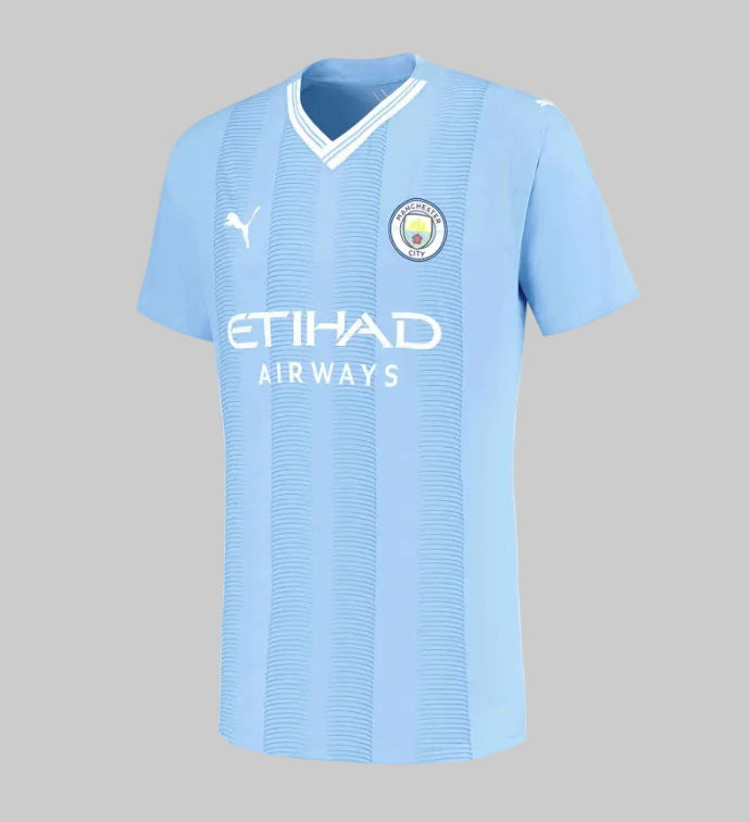 Jersey de casa del Manchester City 2023/24 versión Authentic de Haaland, destacando el color Team Light Blue y el patrón gráfico inspirado en la arquitectura del Etihad Stadium.