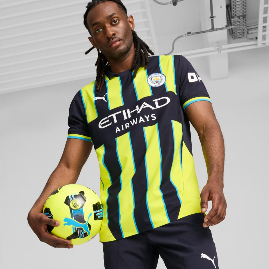 Plano frontal de modelo sosteniendo un balón oficial mientras luce el jersey PUMA Manchester City Authentic Match Away UEFA Champions League 2024/25 de Haaland (Ref. 775085 02) disponible en la boutique de Futbol90MX