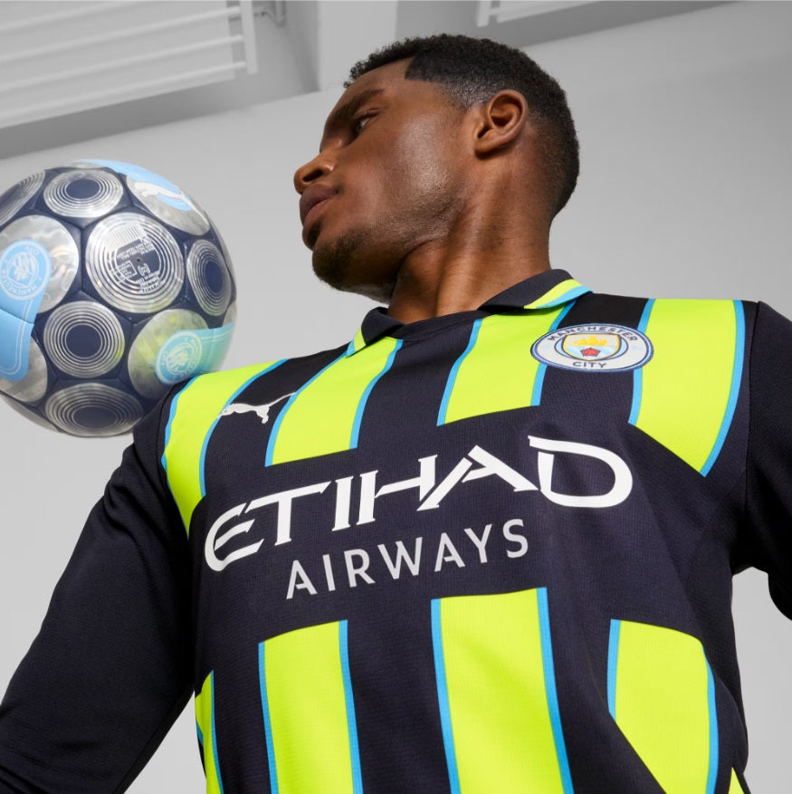 Detalle en primer plano del logotipo de Puma y el escudo del Manchester City en el jersey de manga larga de visita de Erling Haaland 2024/25, stock Futbol90MX