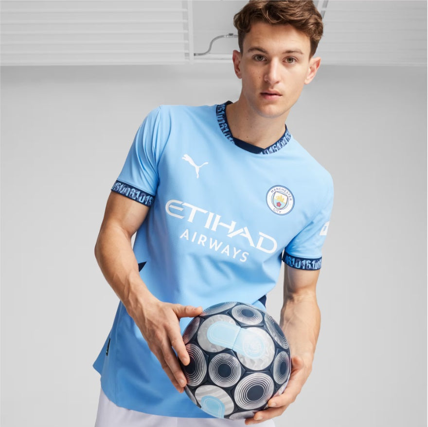 Primer plano de jugador con la camiseta Puma Manchester City Authentic Match Home 2024/25 (Ref. 775050 01) sosteniendo un balón en Futbol90MX