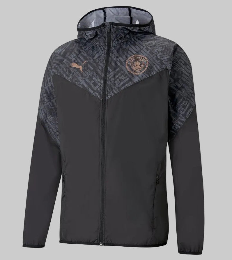 Vista frontal de la chamarra de calentamiento Puma del Manchester City 2020/21 (Ref. 758699 02) en Futbol90MX, destacando su diseño en color negro, capucha integrada con patrón tonal y el escudo oficial del club.