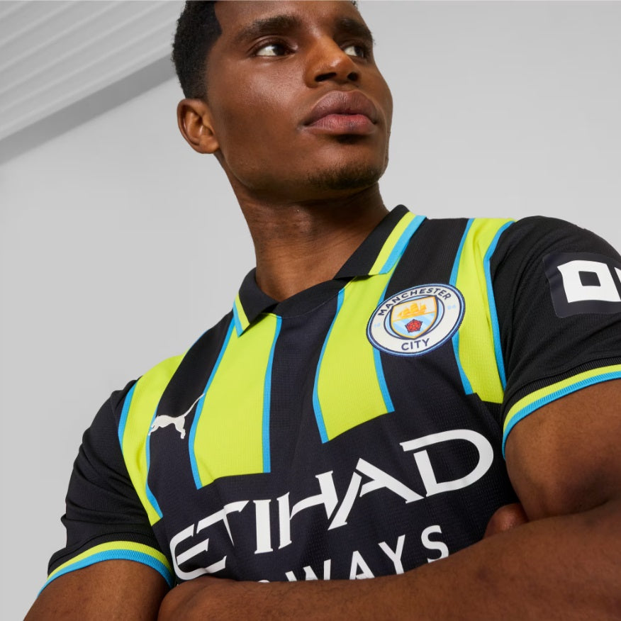 Primer plano del escudo bordado del Manchester City y el logotipo Puma Cat en el jersey away 2024/25, ref 775086 02 - Futbol90MX.