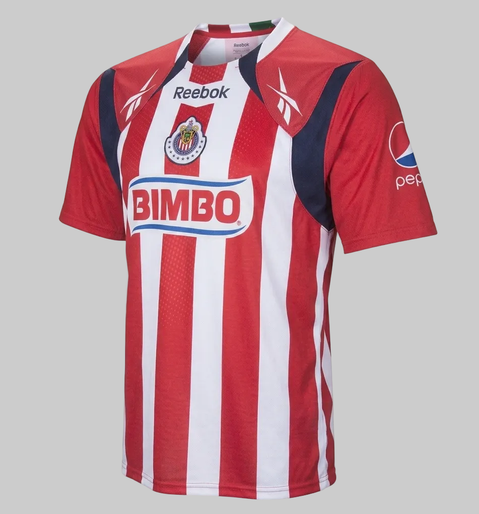 Vista lateral de jersey de local Chivas 2010/11, codigo K11257, destacando el corte ergonómico de la manga y la calidad del tejido técnico Reebok, disponible en Futbol90MX