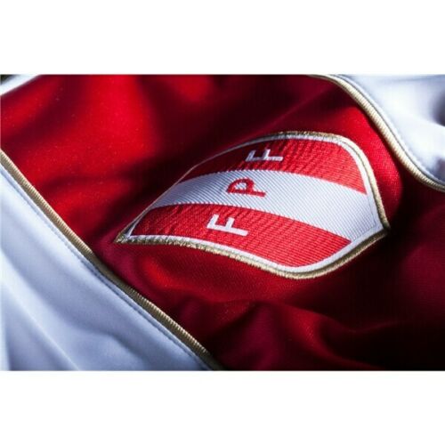 Primer plano del escudo bordado de la Federación Peruana de Fútbol (FPF) en jersey original Umbro 2018.